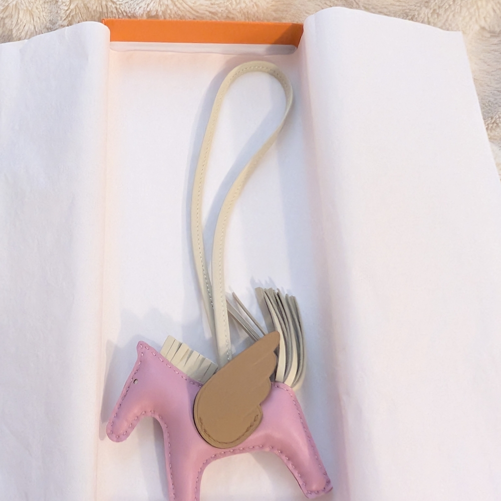 Hermès Rodeo Pegase Charm size PM in colors: Mauve Sylvestre, Craie, and Chai.